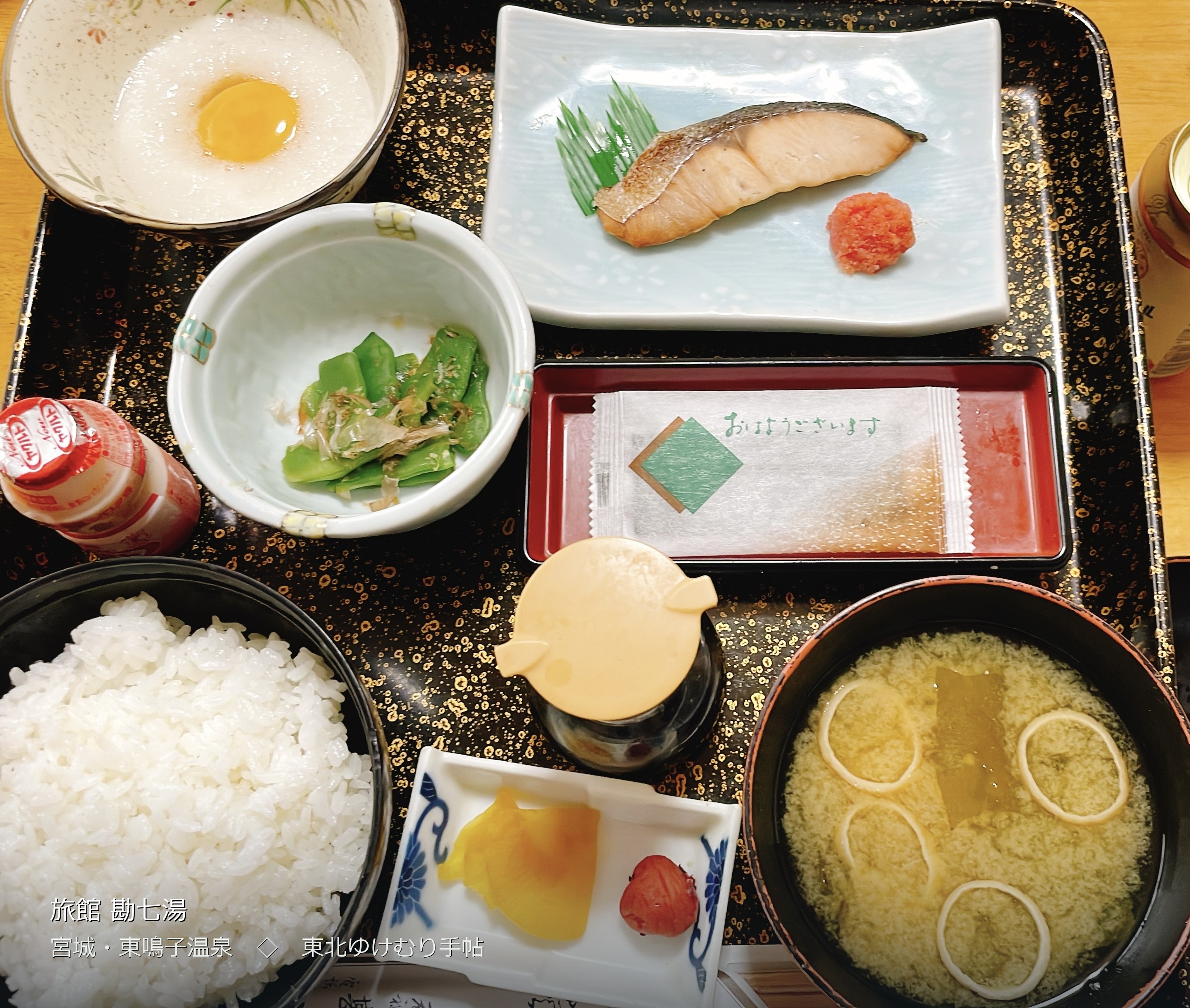 勘七湯の朝食。焼き魚と明太子、温泉玉子、絹さや、味噌汁、ご飯が黒い盆に並ぶ