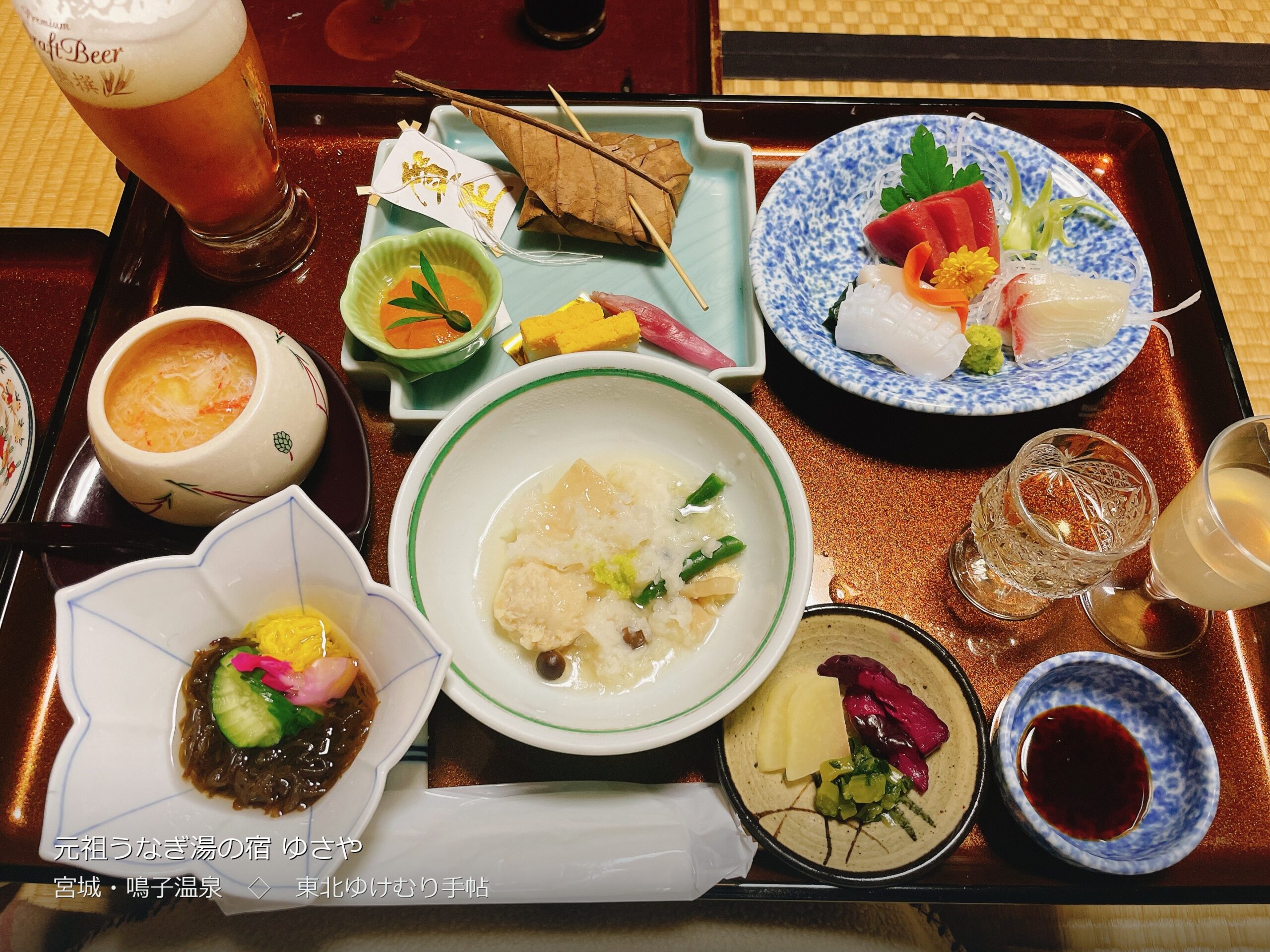 ゆさや旅館の夕食。部屋の畳に置かれた朱塗りのお膳に、刺身・朴葉焼き・茶碗蒸しなどが並ぶ